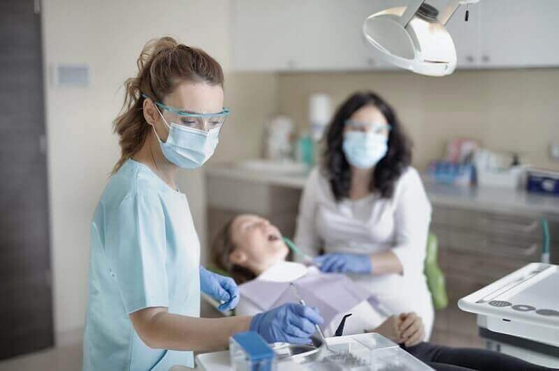 Macquarie Dentists - female dentist reaching the dentist tools from the table