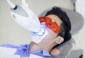 Macquarie Dentists - A man in a dental chair with a red eye glass during a dental procedure.
