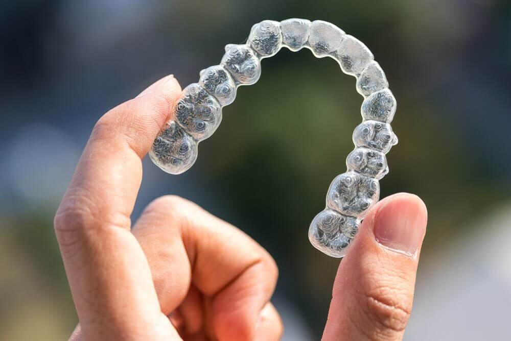 Macquarie Dentists - a hand holding Invisalign